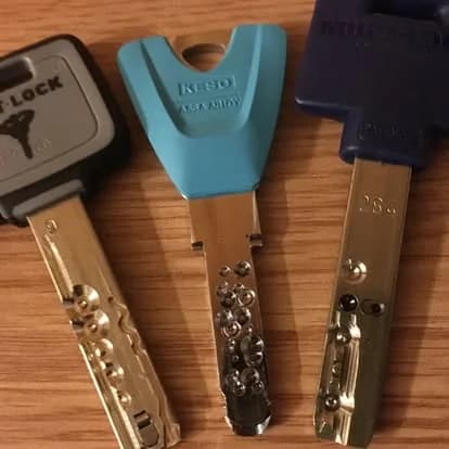 Három biztonsági kulcs egymás mellett, oldalról fényképezve